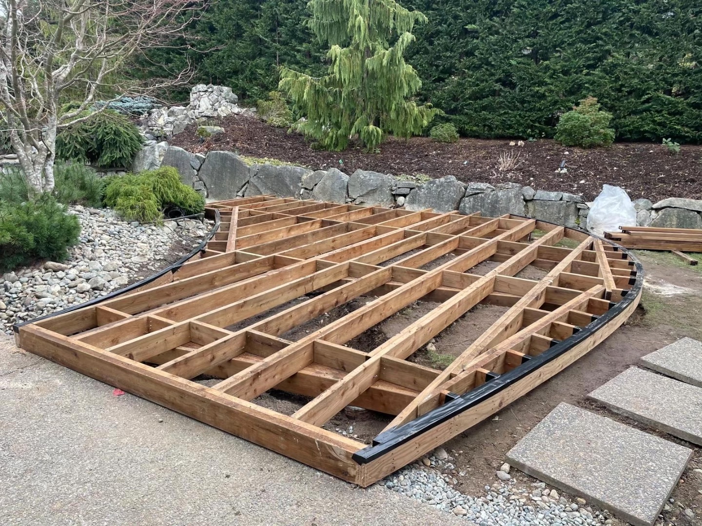 Curved deck framing installation with precision-cut joists and custom layout, showcasing expert construction coordination and project management by WhalleyWorks.
